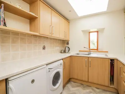 a kitchen with a washing machine and a sink at Swallow's Nest in Keswick