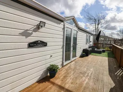a house with a wooden deck next to a building at New Horizon in Carlisle