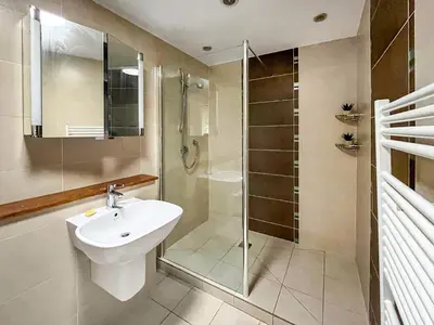a bathroom with a glass shower and a sink at Violet Bank in Cockermouth