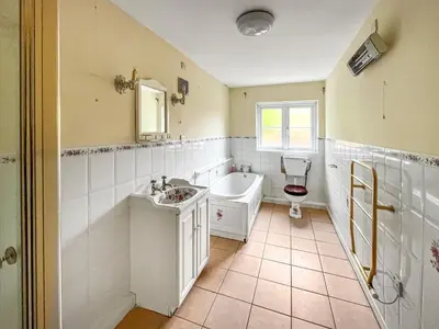 a bathroom with a tub and a sink and a toilet at Violet Bank in Cockermouth