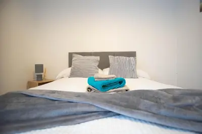 a bed with a blanket and a towel on it at Open House in Carlisle