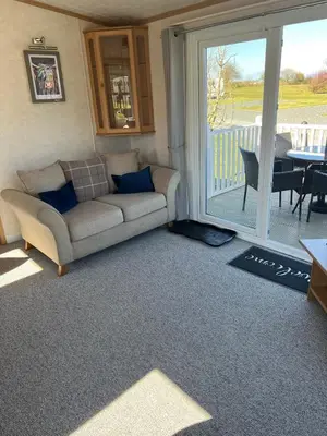 a living room with a couch and a sliding glass door at Penny in Whithorn