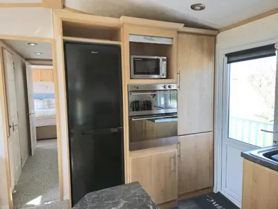 a kitchen with a black refrigerator and a microwave at Penny in Whithorn