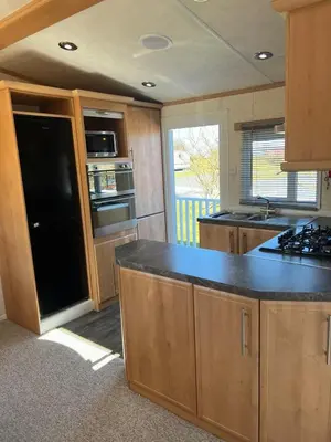 a kitchen with wooden cabinets and a black counter top at Penny in Whithorn