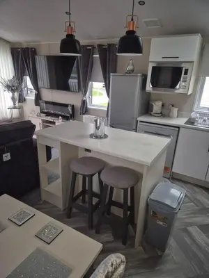 a kitchen with a table and two stools at 2 bedroom platinum in Minishant