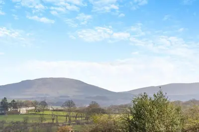 a view of a hill in the distance with mountains in the background at 3 Bed in Cockermouth oc-o31515 in Embleton