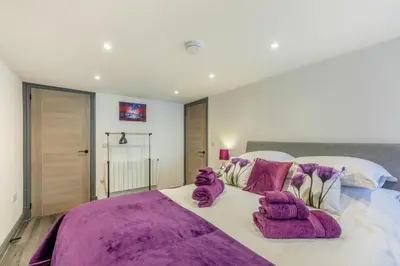 a bedroom with a large bed with purple blankets at 1 Bed in Cockermouth oc-s31514 in Embleton
