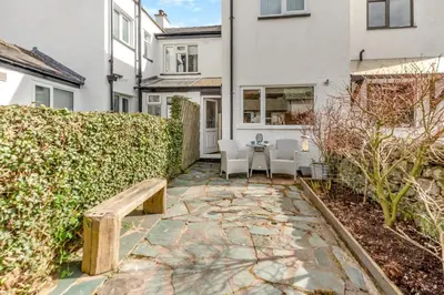 a stone patio with a bench in front of a house at 2 Bed in Braithwaite oc-p31730 in Braithwaite