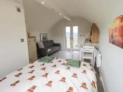 a bedroom with a bed in a room with a kitchen at Shepherds View in Keswick