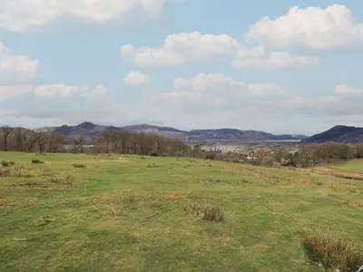 a field of grass with mountains in the background at Shepherds View in Keswick