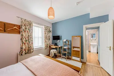 a bedroom with a bed and a desk and a mirror at Hightae B&B in Hightae