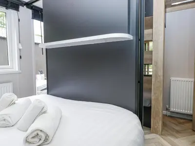 a bedroom with a bed with towels on it at Dubs Luxury Family Pod in Keswick