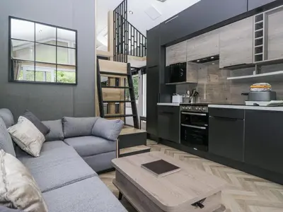 a living room with a couch and a kitchen at Dubs Luxury Family Pod in Keswick