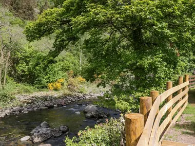 a wooden bridge over a river with at Elter Luxury Pod in Keswick