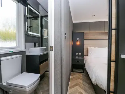 a bathroom with a bed and a sink and a toilet at Woof Luxury Family Pod in Keswick