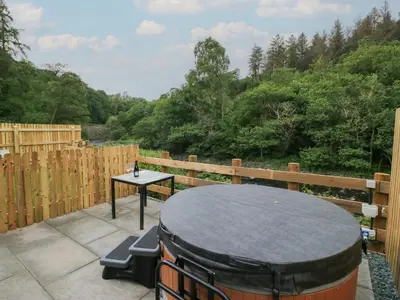 a table and chairs on a patio with a drum at Woof Luxury Family Pod in Keswick