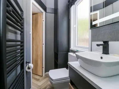 a bathroom with a sink and a toilet and a window at Lingy Luxury Family Pod in Keswick