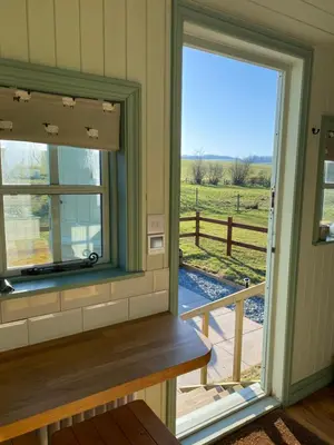 a room with a window and a view of a field at Sunset Snug Shepherd hut in Penrith