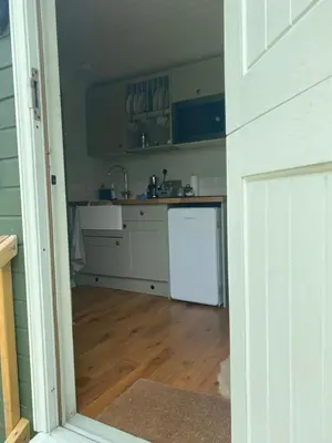a kitchen with a sink and a refrigerator at Sunset Snug Shepherd hut in Penrith