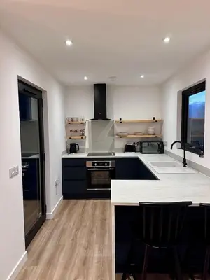 a large kitchen with a stove and a sink at The Byre, Summerhill Farm Stays in Balmaclellan