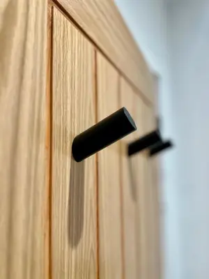 a black door handle on a wooden cabinet at The Barn, Summerhill Farm Stays in Balmaclellan