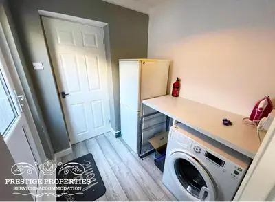 a kitchen with a refrigerator and a washing machine at Victoria Place by Prestige Properties SA in Workington