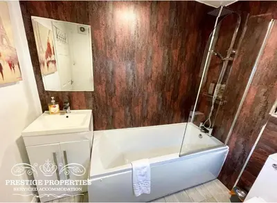 a bathroom with a bath tub and a sink at Victoria Place by Prestige Properties SA in Workington