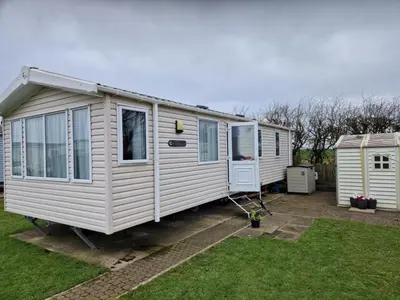 two white mobile homes parked in a yard at Manannan in Maryport