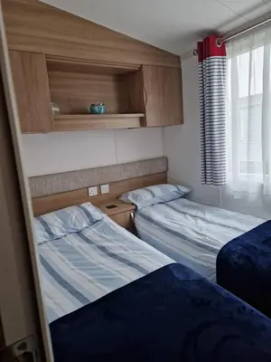 a bedroom with two beds and a window and two beds sidx sidx sidx at Manannan in Maryport