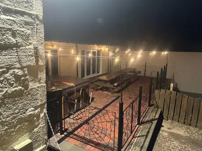 a building with a balcony with lights on it at Belton House Guest Rooms in Wanlockhead