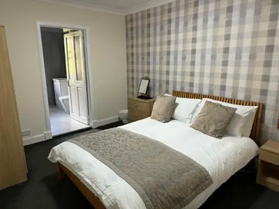 a bedroom with a large bed and a window at Belton House Guest Rooms in Wanlockhead