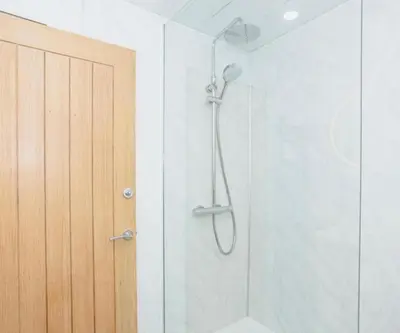 a shower with a glass door in a bathroom at Caul View Apartment in Dumfries in Dumfries