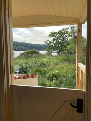 a view of a field from a window of a house at The Secret Shepherds Hut- Off Grid Retreat in New Galloway