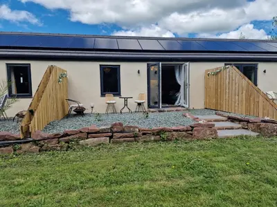 a house with a stone wall in front of it at The Burrow by Blake View Holidays a peaceful boutique retreat 3 miles from Ennerdale- standard twin or super-king bed available in Rowrah