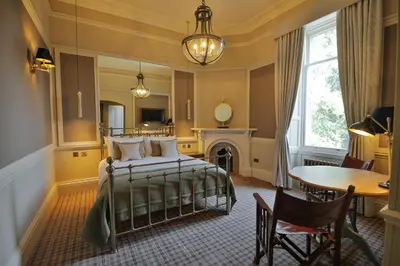 a bedroom with a bed and a table and a chair at Cornhill Castle in Biggar