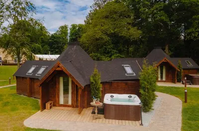 a small house with a hot tub on a deck at Cornhill Castle in Biggar