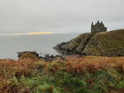 a castle sitting on top of a hill next to the ocean at Cosy Holiday Home Portpatrick in Portpatrick