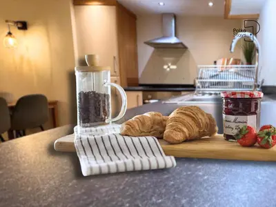 a kitchen counter with a blender and croissants on a cutting board at The Stables Lake District Retreat by PolkaStays in Troutbeck