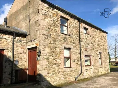 an old stone building with a brown door and a building at The Stables Lake District Retreat by PolkaStays in Troutbeck