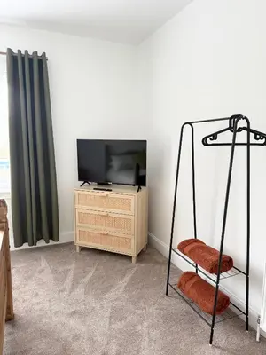 a living room with a flat screen tv and a chair at Modern 2 bed with secure driveway in Dumfries