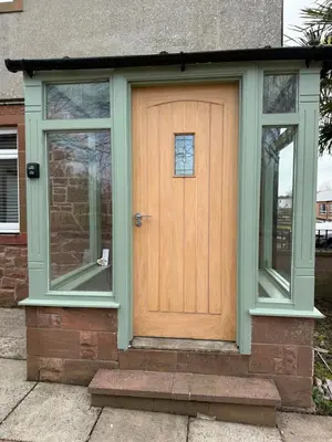 a wooden door with two windows on a house at Modern 2 bed with secure driveway in Dumfries