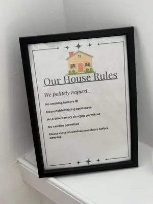 a framed picture of our house rules on a shelf at Modern 2 bed with secure driveway in Dumfries