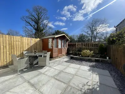 a patio with a table and chairs and a fence at Farmers Retreat in Keswick