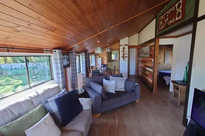 a living room with couches and a couch and a room with at Wildwood Cabin - Sleeps 6 Hot Tub & Parking in Beattock