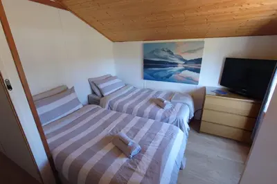two beds in a small room with a television at Wildwood Cabin - Sleeps 6 Hot Tub & Parking in Beattock