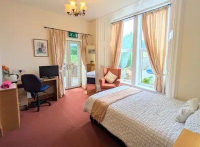 a bedroom with a bed and a desk and a window at Ensuite rooms, self-catering in shared kitchens in Dumfries