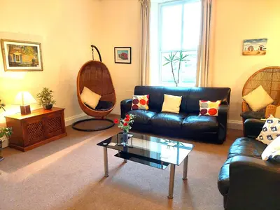a living room with a leather couch and a coffee table at Ensuite rooms, self-catering in shared kitchens in Dumfries