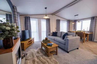 a living room with a couch and a tv at Crofthead Holiday Park in Ayr