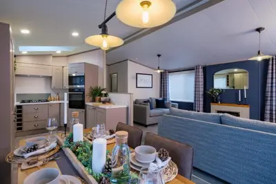 a kitchen and living room with a table and a couch at Crofthead Holiday Park in Ayr