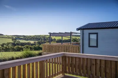 a wooden deck next to a small house at Crofthead Holiday Park in Ayr